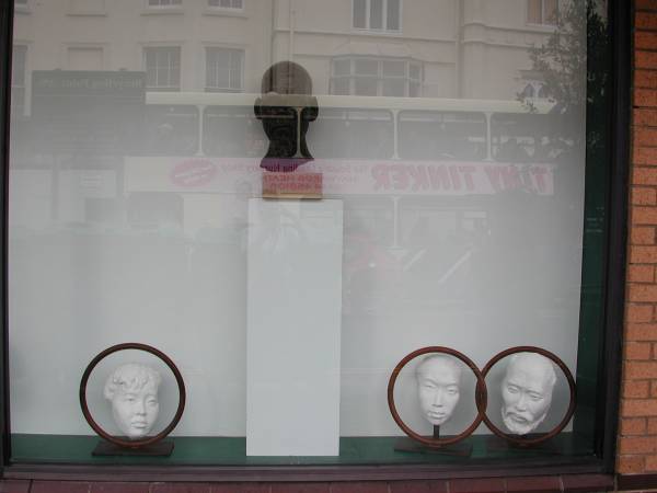 Right section of window in gallery showing sculptures by Laury Dizengremel