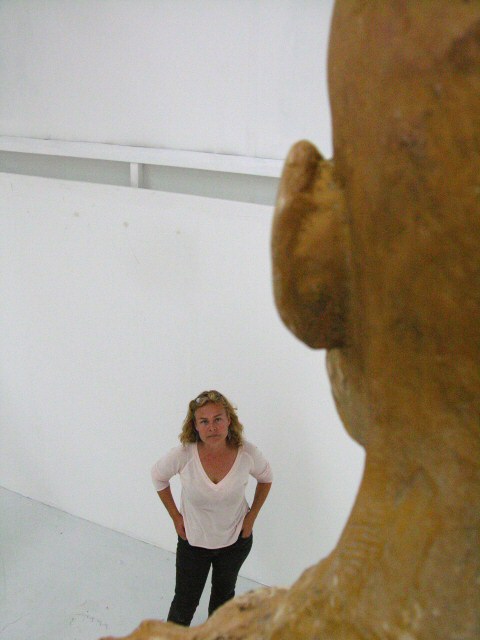 Sculptor looking up at a monumental sculpture in UCCA exhibition studio for MFA degree show