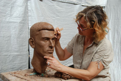 Sculptor Laury Dizengremel working on bust of Novak Djokovic